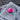 Pink colored course logo golf ball on a gray towel with a blurred wood background