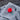 Red colored course logo golf ball on a gray towel with a blurred wood background
