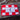 Red and white checkered flag with a black course logo on a wooden surface.
